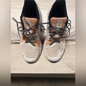 On Cloud Running Shoes in Peach,  White and blue.